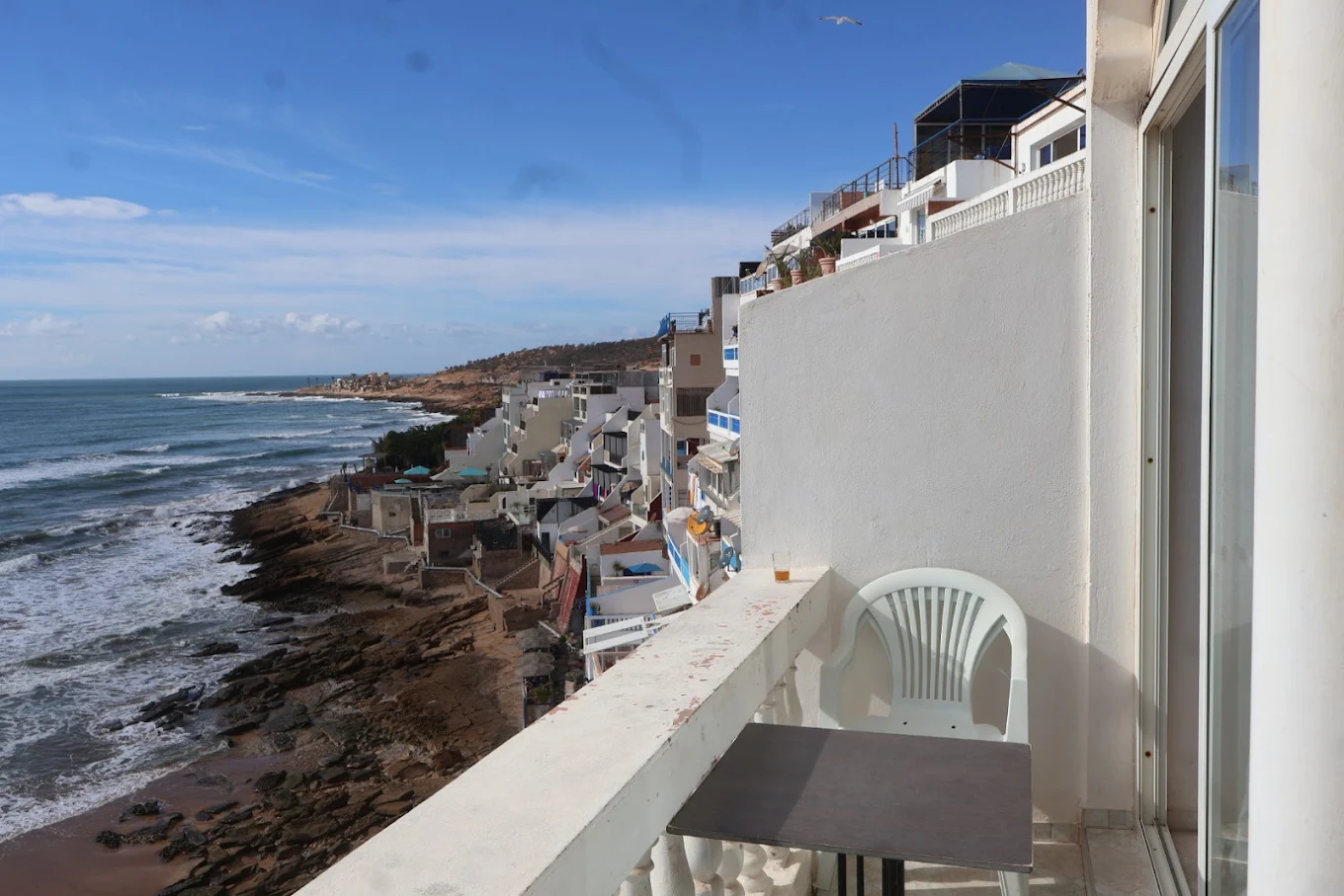 A luxury hotel room with a balcony and an ocean view